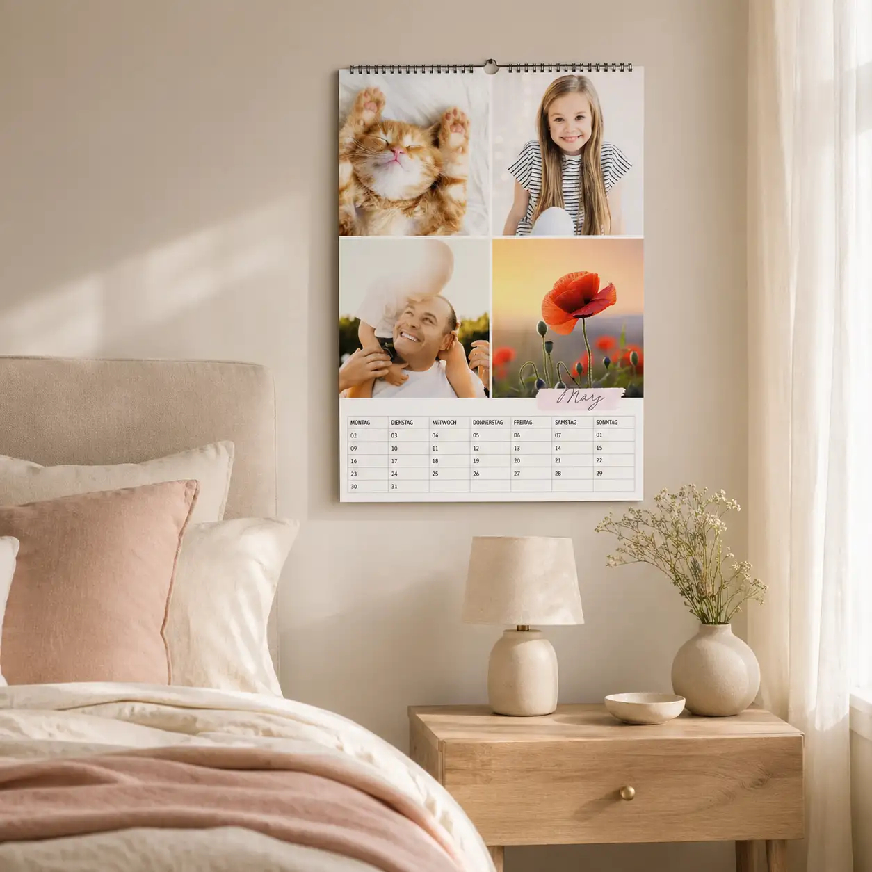 Monatskalender mit Fotocollage aus schlafender Katze, Mädchen, Vater mit Kind und roter Mohnblume in einem gemütlichen Schlafzimmer an der Wand.