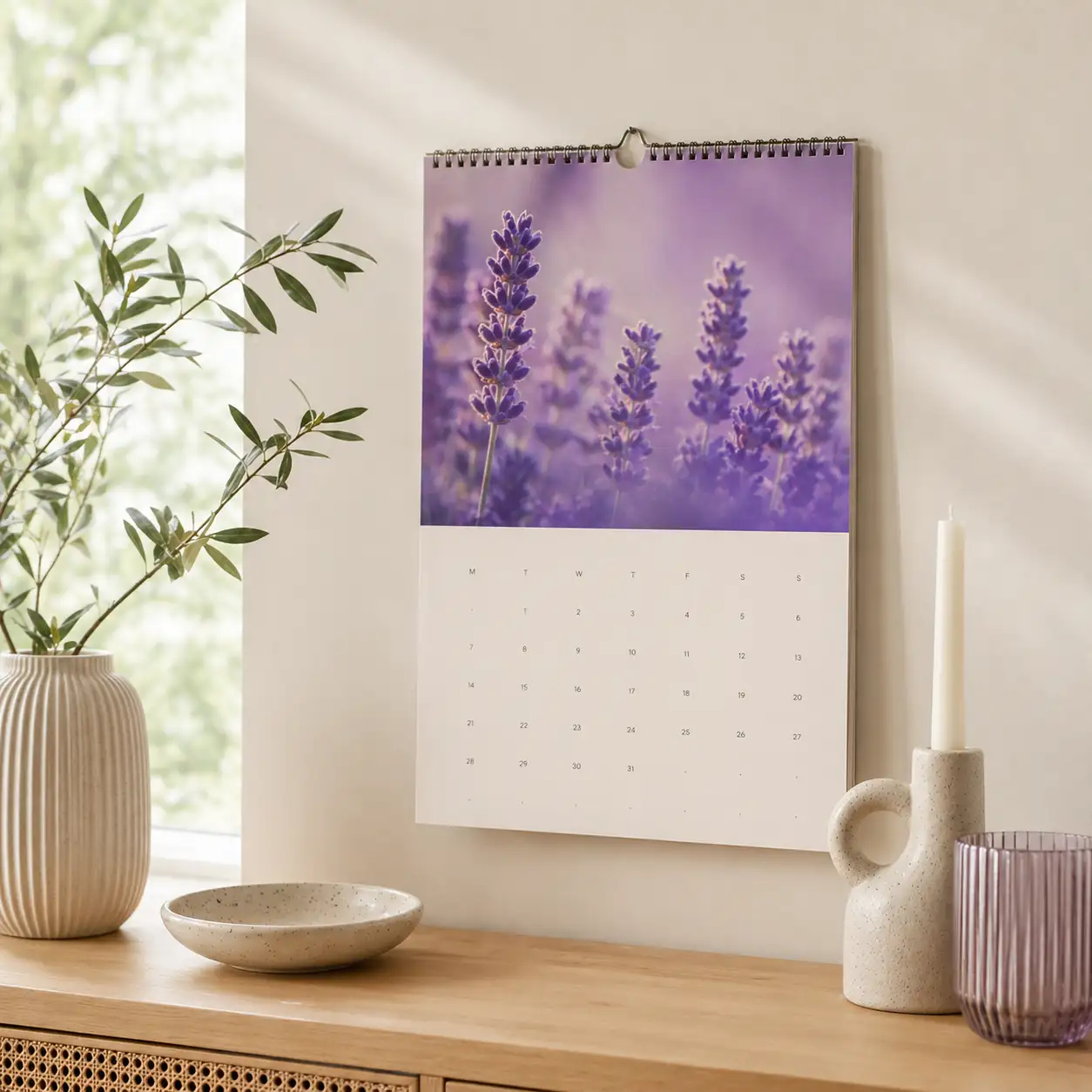 Monatskalender mit Lavendelmotiv an heller Wand in einem minimalistischen Wohnraum